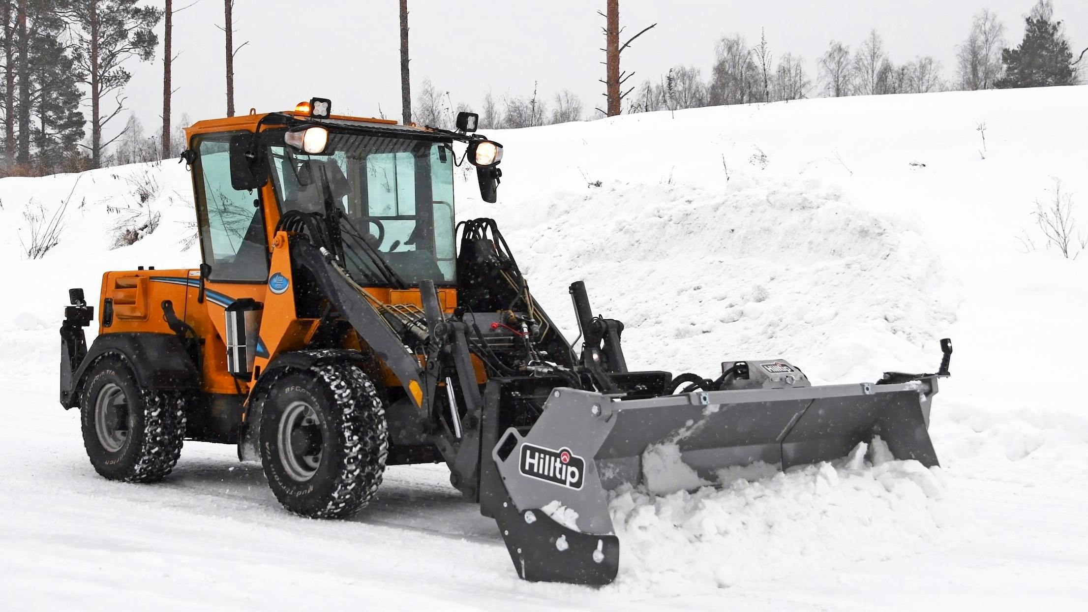 Hilltip SnowStriker SFT Flex box plow on a wheel loader pushing snow.