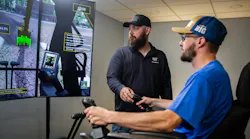 Caterpillar Next Gen Excavator Utilities Package. Man directs an operator on a simulator.