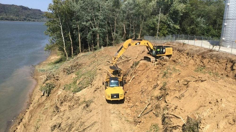 Excavator and ADT on a slope next to water