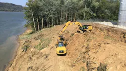 Excavator and ADT on a slope next to water