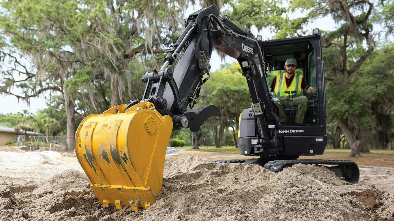 John Deere mini excavator digging in the dirt.