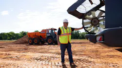A man checks the fan on a Develon articulated dump truck.