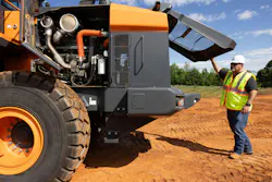 Operator lifts the engine compartment on a Develon wheel loader.