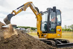 Caterpillar 302.4 mini excavator digging dirt.