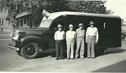 Four men pose beside an Omaha Standard-bodied truck.