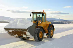A Volvo Construction Equipment wheel loader carrying snow in a bucket.