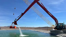 An excavator dredging water