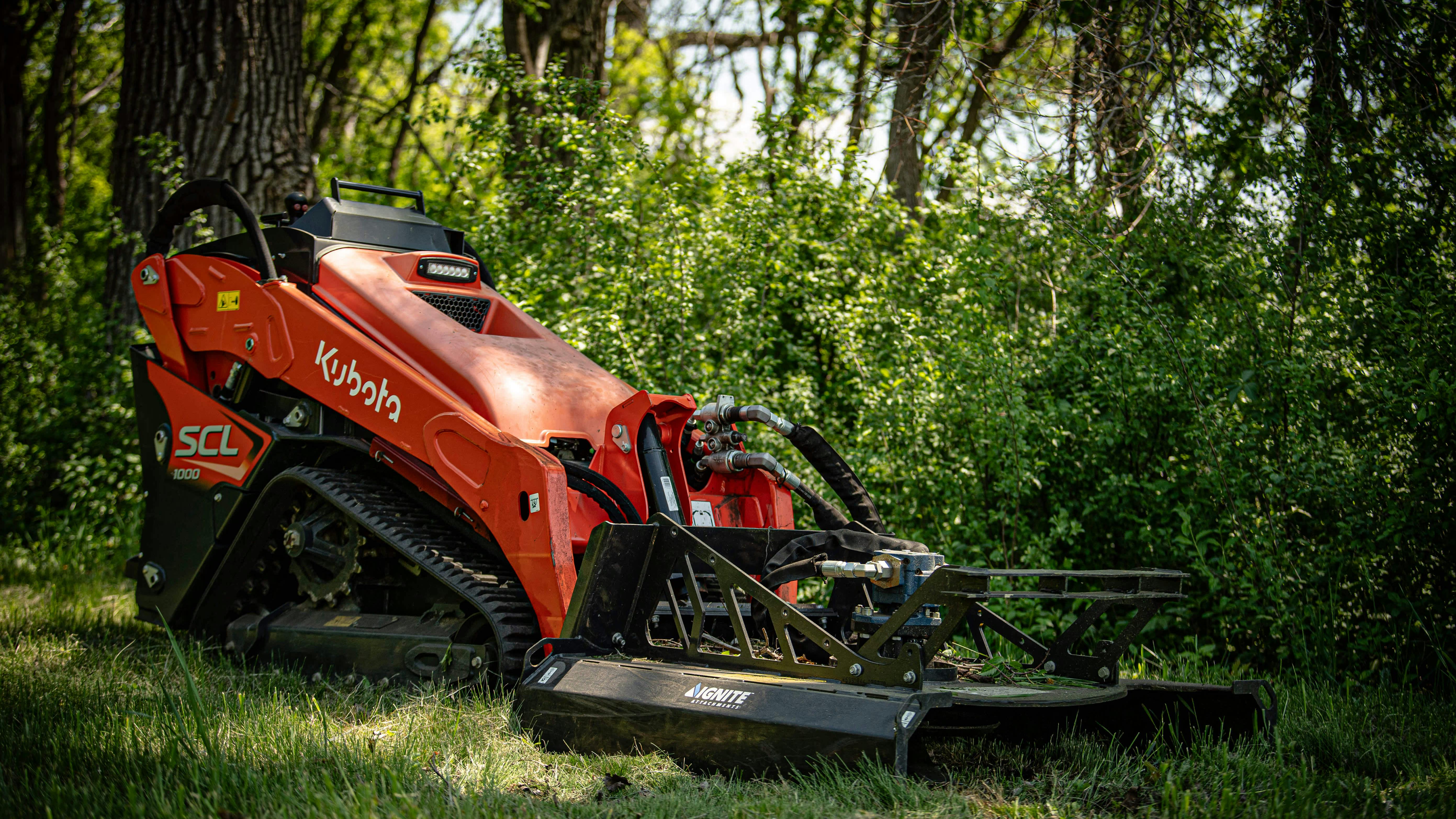 Ignite 44-inch Mini Brush Cutter on a Kubota mini skid steer, sitting in the woods.