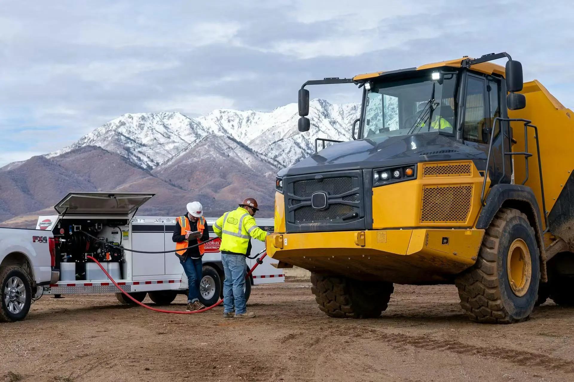 Men refuel a ADT with a Thunder Creek maintenance and refueling truck.