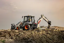 A Bobcat B760 backhoe loader dumping dirt in the distance.