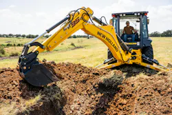 A New Holland B95D loader backhoe moving dirt from a trench.