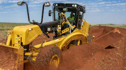 A Caterpillar motor grader slicing through the dirt.