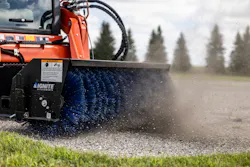 A compact loader users an Ignite broom attachment.